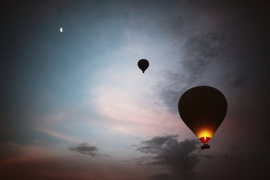 Hot air balloons at sunrise with moon