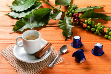 White cup of hot coffee on wooden table. Orange wood pinus.