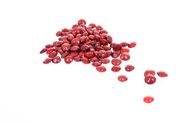 Red sandalwood seeds (Adenanthera pavonina) seeds on white background.