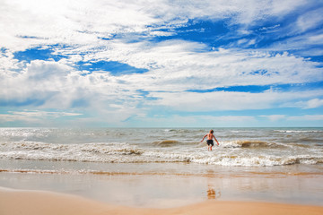Boy jumping in the waves at the beach