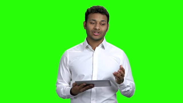 Young Indian business man giving a presentation. Handsome business trainer using tablet device. Green Chroma Key background.