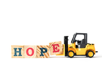 Toy forklift hold letter block e to complete word hope on white background