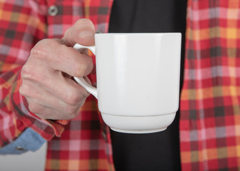 A man holding white mug