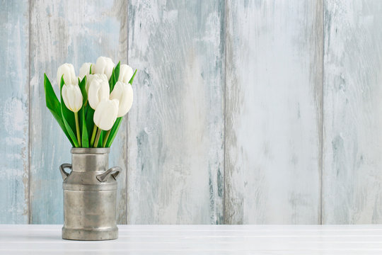 Bouquet of white tulips in vintage silver can.