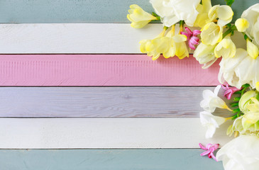 Beautiful white tulips and yellow freesias on striped wooden background
