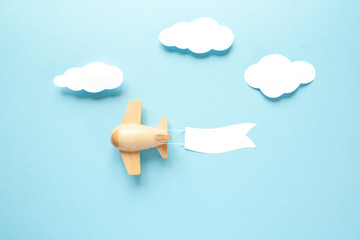 Children's wooden plane in the sky carries an empty banner.