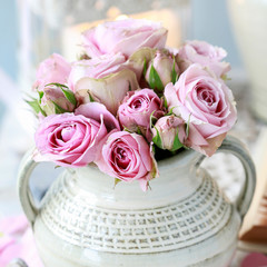 Bouquet of pink roses in ceramic vase.