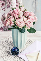 Bouquet of pink roses in ceramic vase.