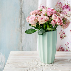 Bouquet of pink roses in ceramic vase.