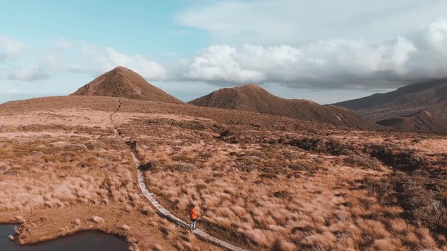 Dramatic drone aerial footage of Mount Taranaki, Egmont National Park, New Zealand 4k circling 2 hikers
