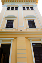 Fototapeta na wymiar the beautiful yellow building ,Vintage building and many black window . 