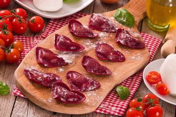 Red heart ravioli with tomato, mozzarella and basil.