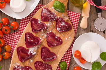 Red heart ravioli with tomato, mozzarella and basil.