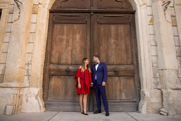 In love wedding couple posing outdoor in front of old castle wooden gate