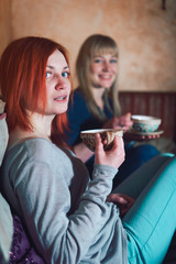 Two girls relax, have fun in the cafe. smoke hookah drink tea. The concept of smoking tobacco, refueling mix for hookah. Vertical photo