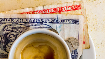 Havana Cuba. Close up of Cuban pesos and espresso coffee on wood table surface.