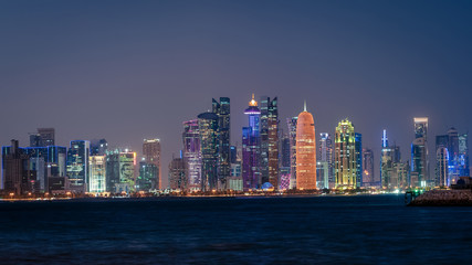 Naklejka premium Doha Qatar skyline cityscape with skyscrapers at night