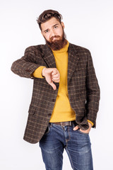 businessman looking at camera and showing his thumb down while standing against white background