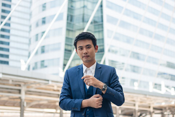 Young businessman adjusting cufflink his blue suit.