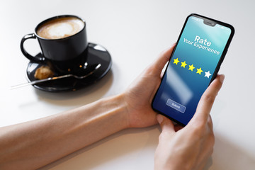 Rate your experience customer satisfaction review Five Stars on mobile phone screen. Business...