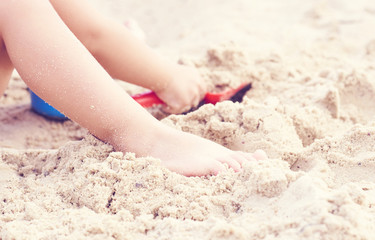 Close-up of a child hands, playing in the sand on the beach