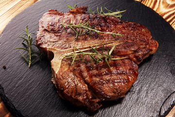 Grilled T-bone steak on stone cutting board.
