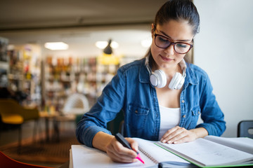 Beautiful student girl learning in a library