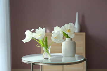 Beautiful flowers on glass table in room