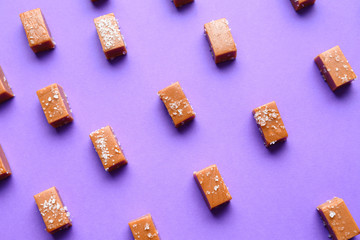Tasty candies with salt on color background