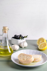Plate with fresh bread and tasty olive oil on table