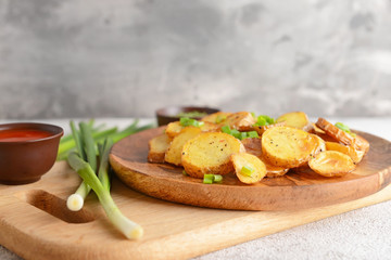 Plate with tasty baked potato and onion on wooden board