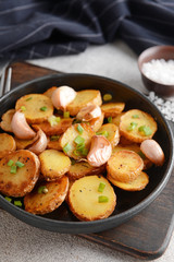 Frying pan with tasty baked potato on table