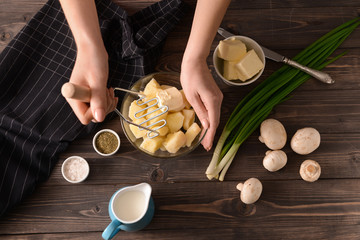 Woman preparing tasty mashed potato at table