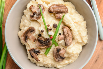 Bowl with tasty mashed potato on table, closeup