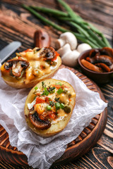 Tasty baked potato on wooden board