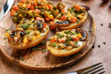 Plate with tasty baked potato on table
