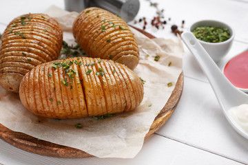 Plate with tasty baked potato on white table
