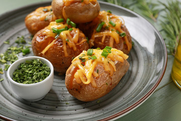 Tasty baked potato with herbs on plate