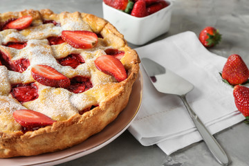 Tasty strawberry pie on grey table