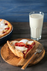 Piece of tasty strawberry pie on wooden table