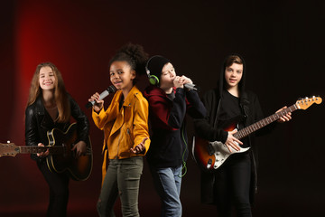 Band of teenage musicians on dark background