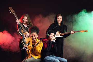 Band of teenage musicians on dark background