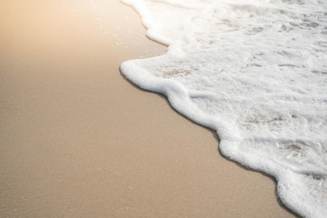 sea wave with bubbles on the sand beach