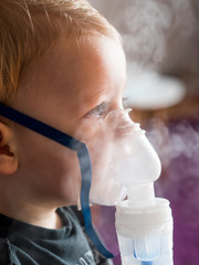 Blonde boy with blue eyes and oxygen mask
