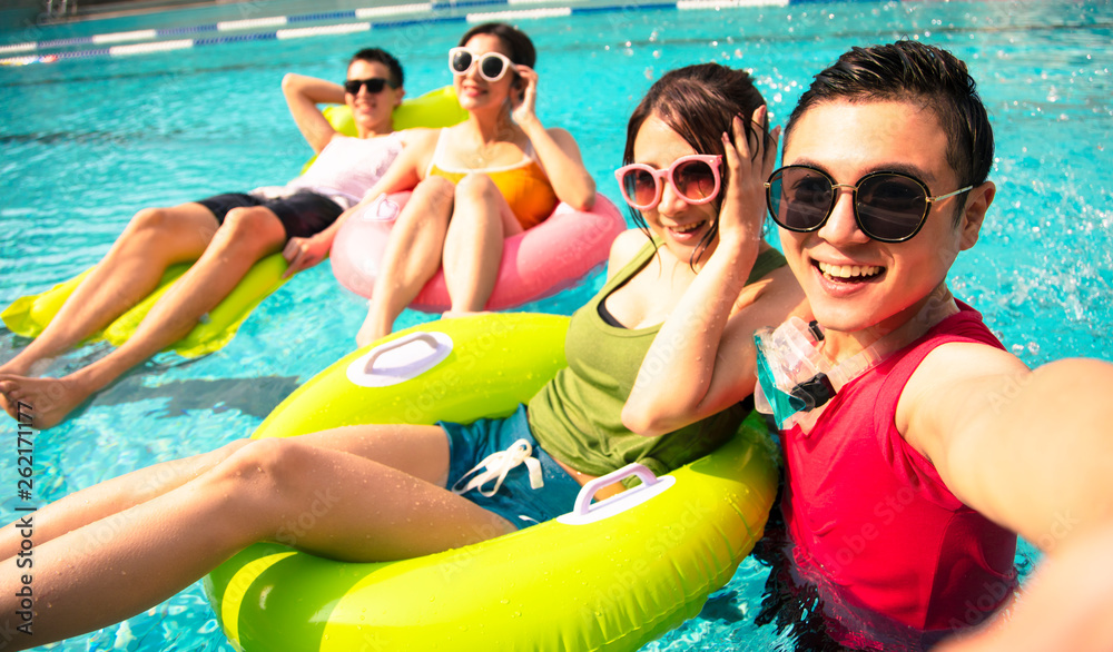 Wall mural happy young friends taking selfie at the swimming pool