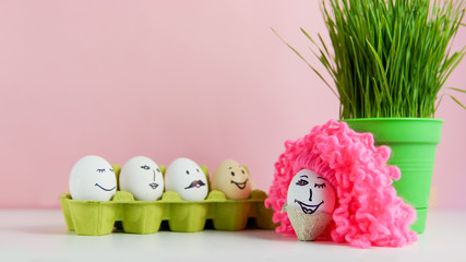 Funny easter faces on egss and one egg with a pink wig	