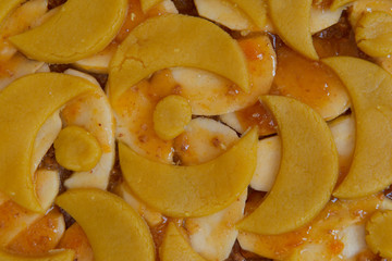 Very close view on apricot and apple jam cake with yellow eggs pastry before cooking.