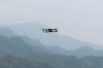 Fototapeta na wymiar flying drone with sky and mountain with soft-focus and over light in the background