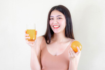 Beautiful beauty woman Asian cute girl feel happy drinking orange juice for good health in the morning , enjoying time in her home  white bedroom background - lifestyle beauty woman concept