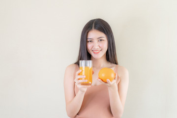 Beautiful beauty woman Asian cute girl feel happy drinking orange juice for good health in the morning , enjoying time in her home  white bedroom background - lifestyle beauty woman concept